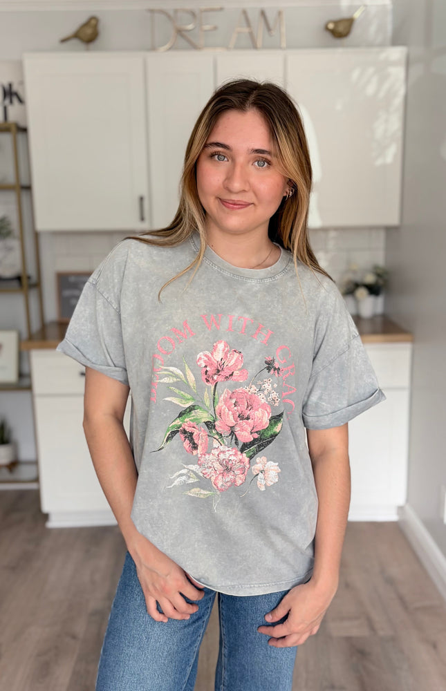 Soft vintage floral graphic tee on model (5'7", Size Small) with 'Bloom With Grace' print and relaxed boyfriend fit