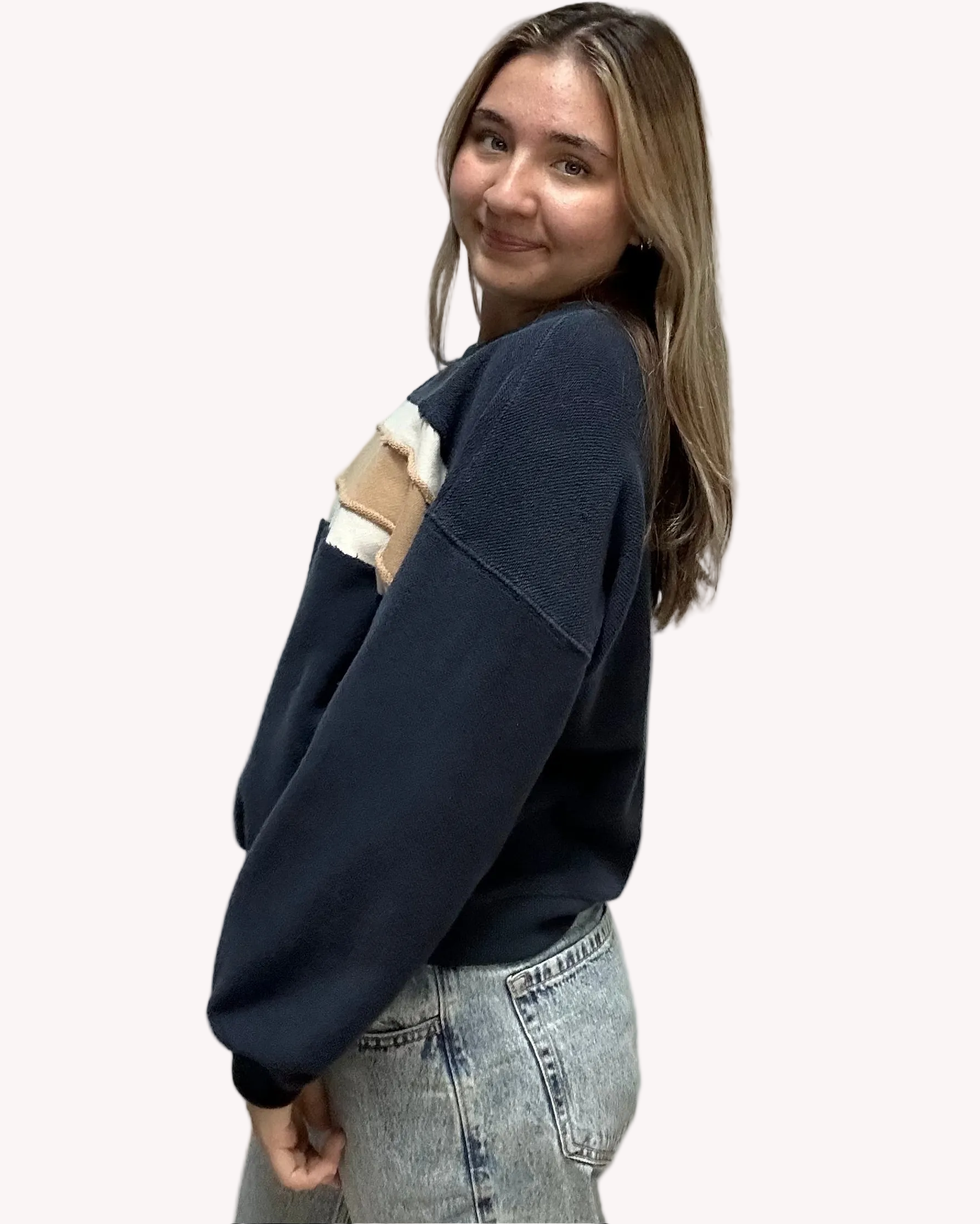 Cozy pullover sweatshirt with a relaxed fit, dropped dolman sleeves, and a bold contrast stripe detail, photographed on a soft-linen background.