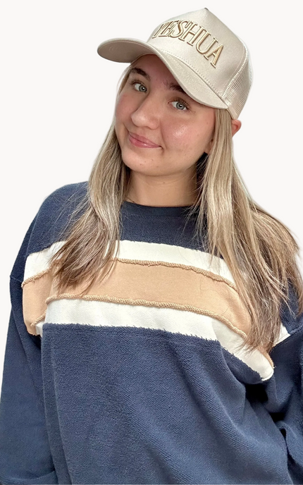 Cozy pullover sweatshirt with a relaxed fit, dropped dolman sleeves, and a bold contrast stripe detail, photographed on a soft-linen background.