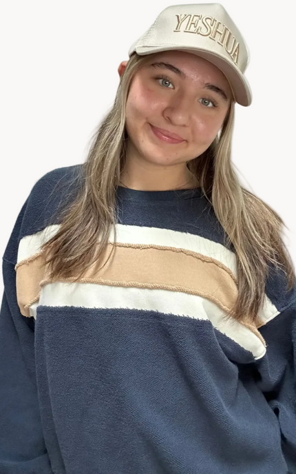 Cozy pullover sweatshirt with a relaxed fit, dropped dolman sleeves, and a bold contrast stripe detail, photographed on a soft-linen background.