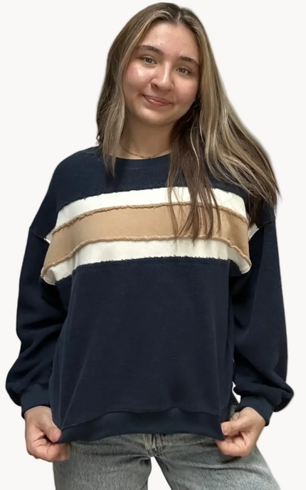Cozy pullover sweatshirt with a relaxed fit, dropped dolman sleeves, and a bold contrast stripe detail, photographed on a soft-linen background.