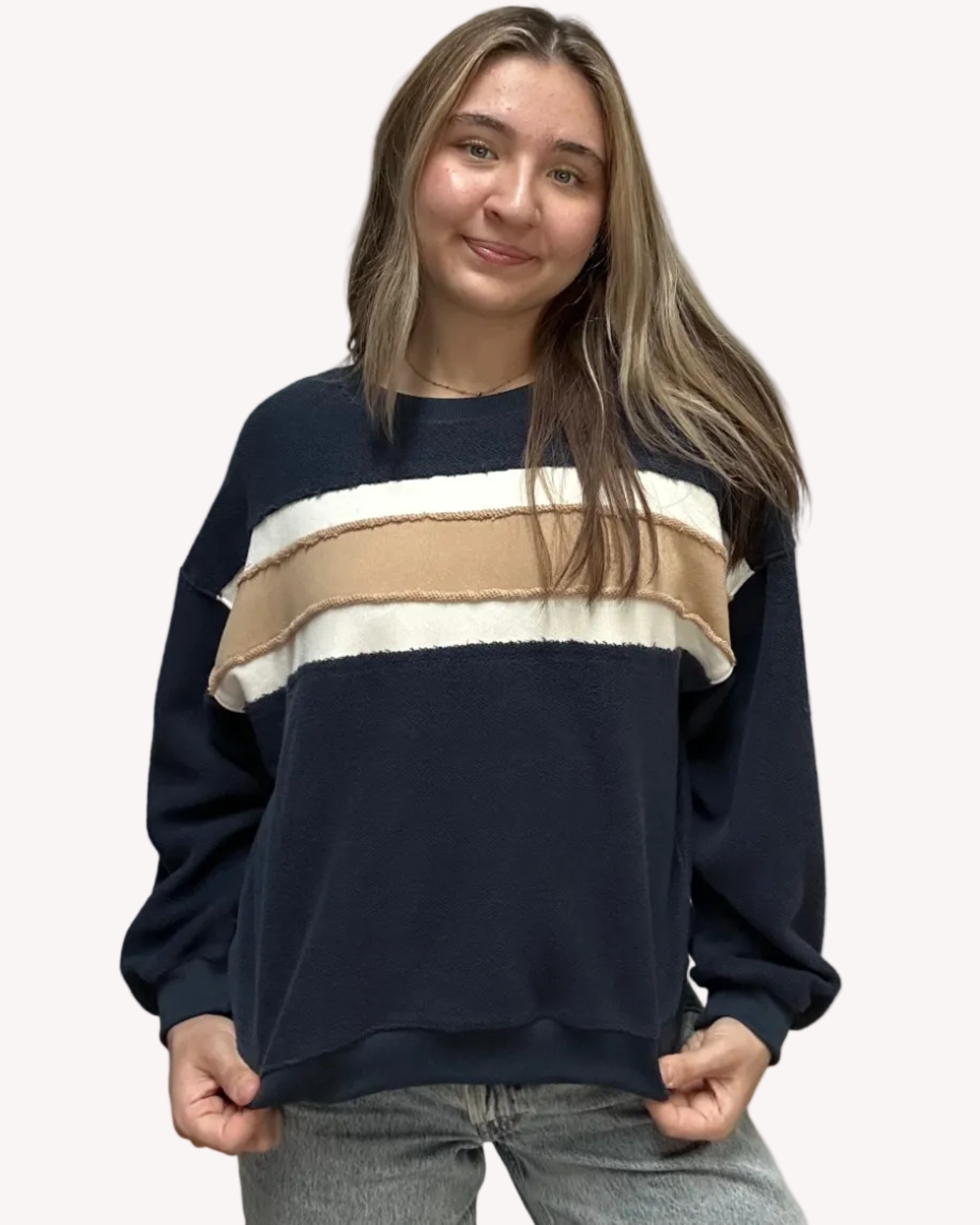 Cozy pullover sweatshirt with a relaxed fit, dropped dolman sleeves, and a bold contrast stripe detail, photographed on a soft-linen background.