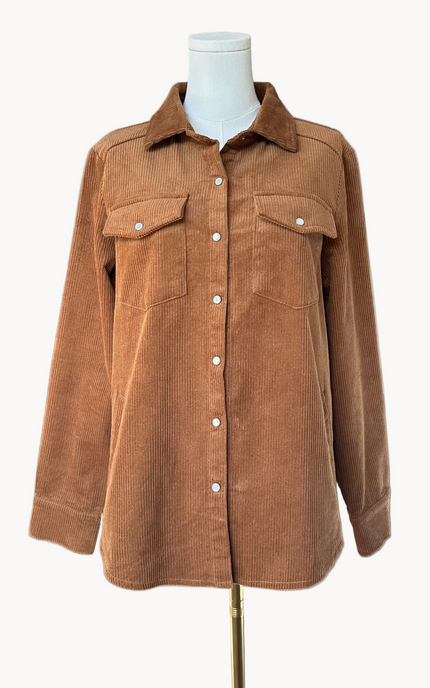 Soft corduroy button-down shacket with a relaxed fit and side pockets, shown in a neutral tone against a clean soft-linen background, styled as a cozy layering piece.