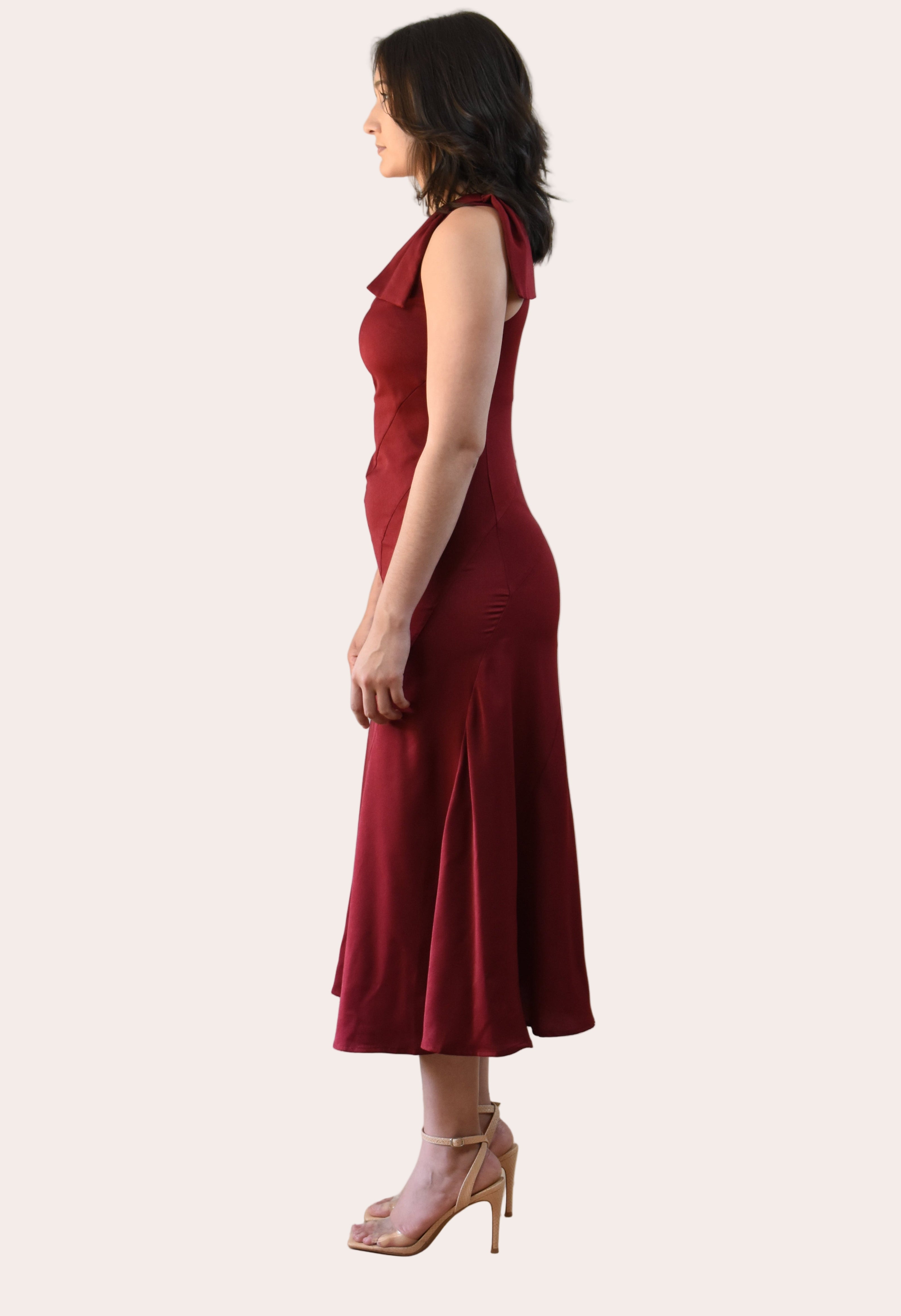 Cranberry Grace Dress with one-shoulder bow detail, slanted seamwork, and flared midi hem, designed for elegant movement, photographed on Soft Linen background.