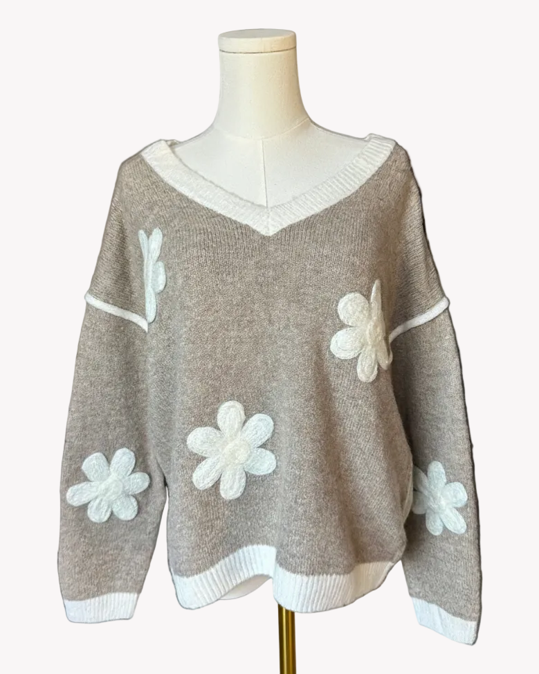 Mocha V-neck drop-shoulder sweater with floral appliqués and contrast trim at neckline, cuffs, and hem, photographed on a Soft Linen background for Justyna Grace Boutique.