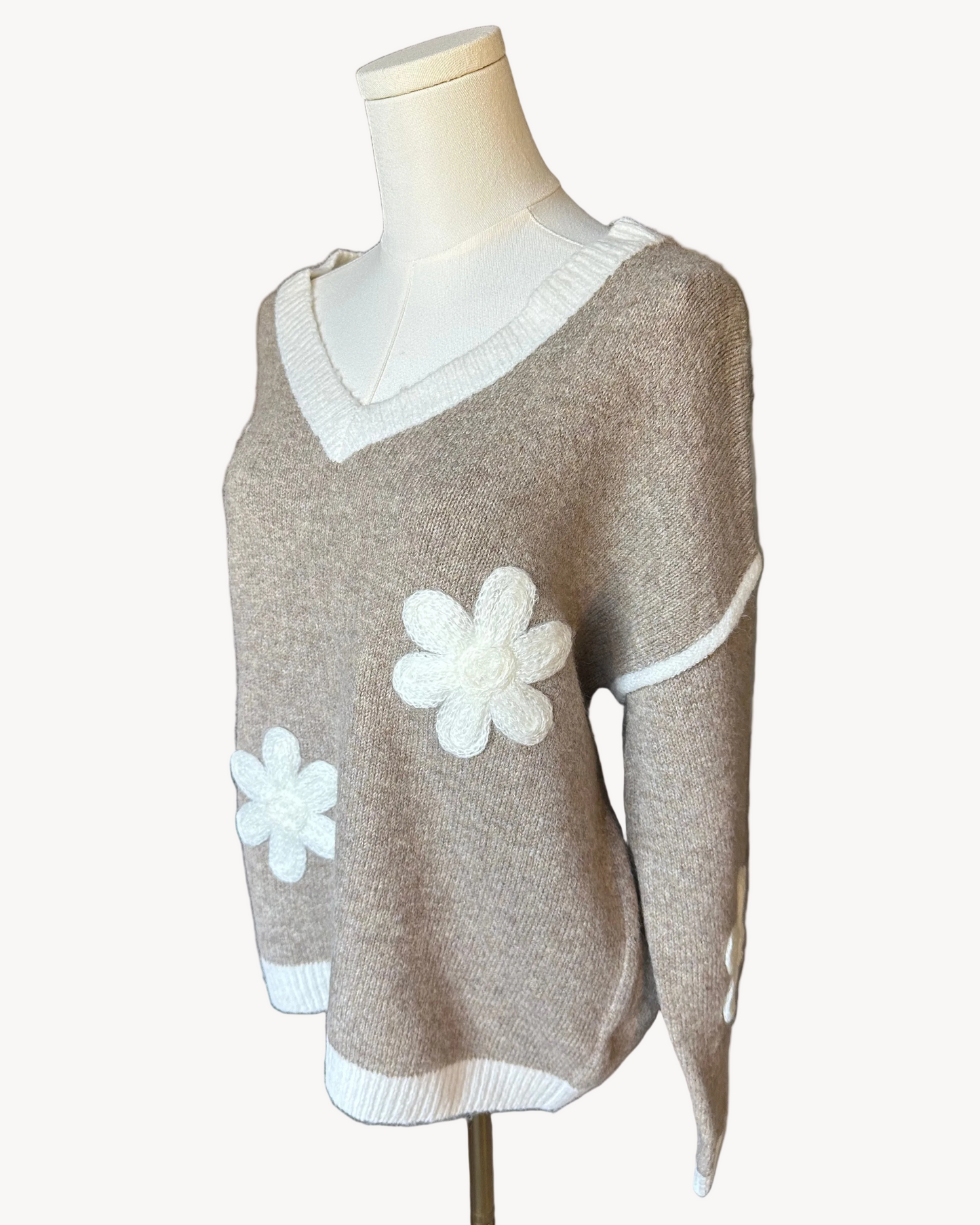Mocha V-neck drop-shoulder sweater with floral appliqués and contrast trim at neckline, cuffs, and hem, photographed on a Soft Linen background for Justyna Grace Boutique.