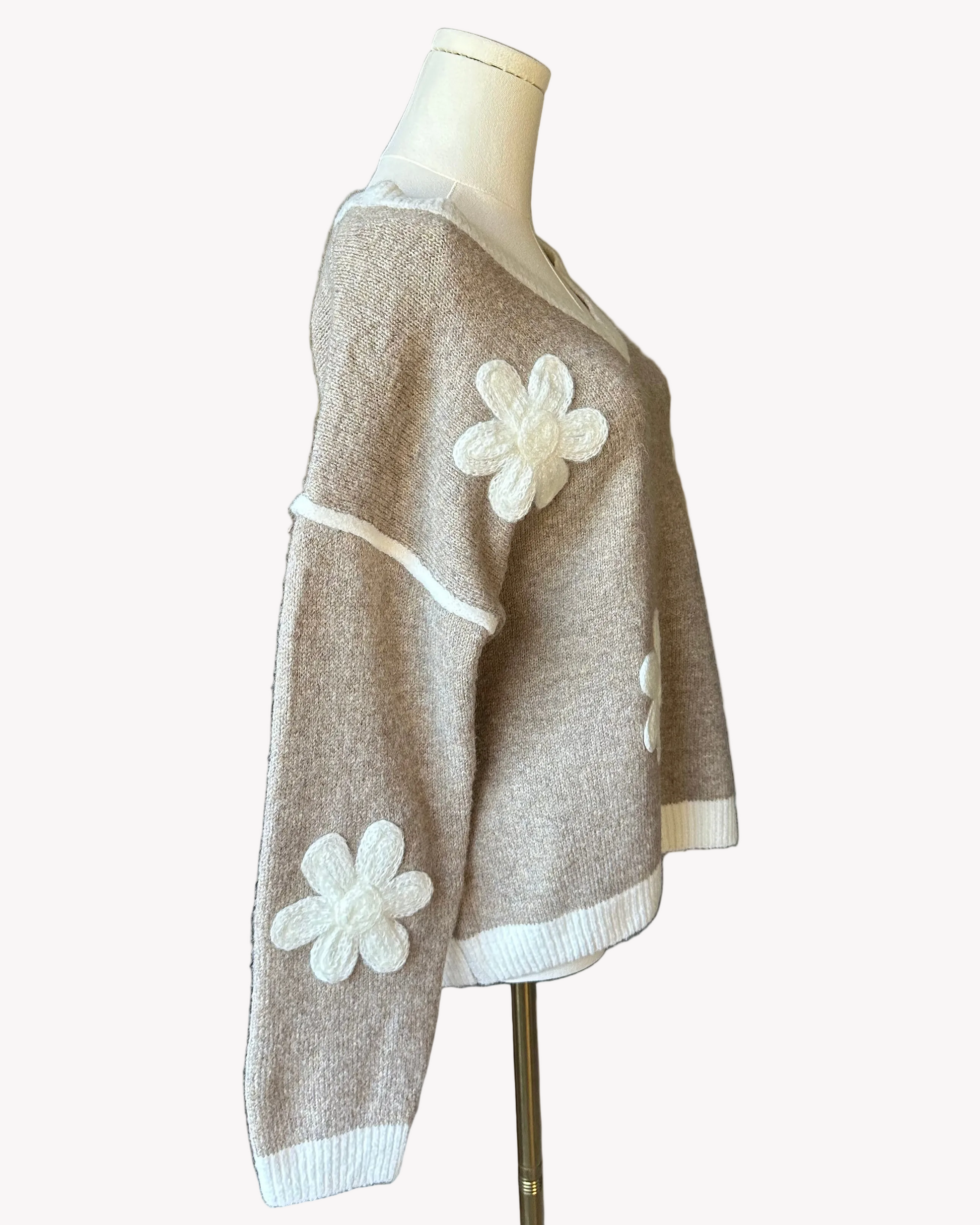 Mocha V-neck drop-shoulder sweater with floral appliqués and contrast trim at neckline, cuffs, and hem, photographed on a Soft Linen background for Justyna Grace Boutique.