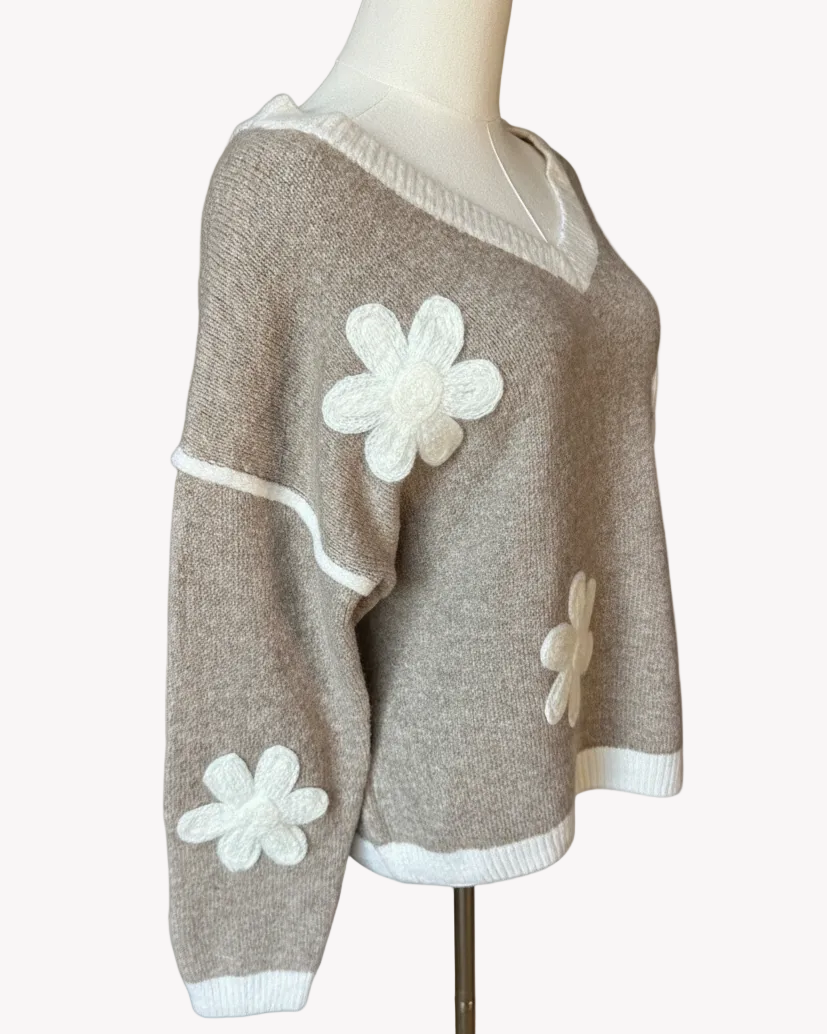 Mocha V-neck drop-shoulder sweater with floral appliqués and contrast trim at neckline, cuffs, and hem, photographed on a Soft Linen background for Justyna Grace Boutique.