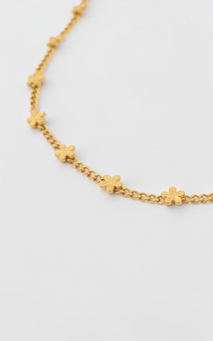 Delicate daisy pendant necklace in 18K gold PVD displayed full length, flat lay view