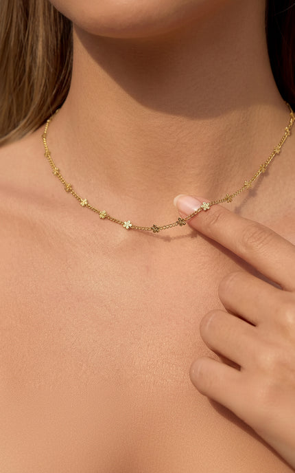 Woman wearing daisy pendant necklace while moving naturally, showing how pendant drapes