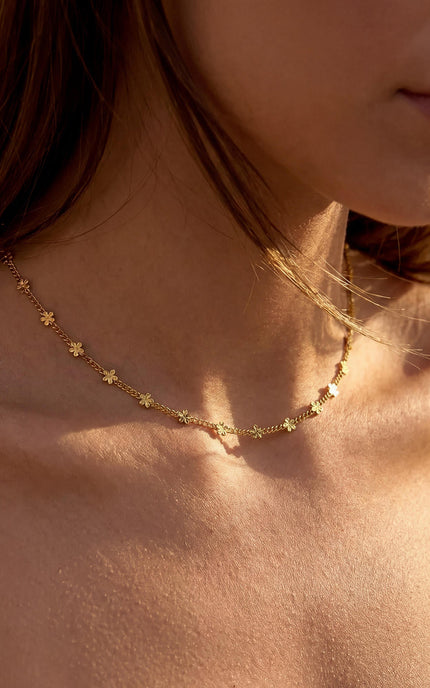 Delicate daisy necklace on model in motion, demonstrating lightweight comfort