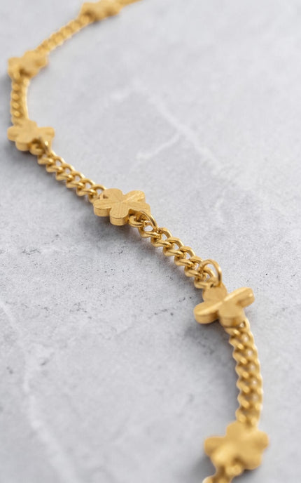 Close-up of intricate daisy flower pendant detail on gold PVD necklace
