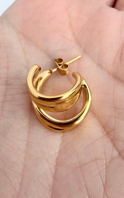Macro shot of double twist hoop earring showing sculpted gold design and lightweight stainless steel construction