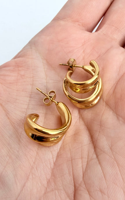 Close-up of double twist hoop earring showing sculpted gold design and 18k gold PVD finish over stainless steel