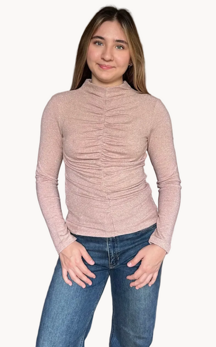 Woman wearing a ruched long-sleeve top and jeans on a white background