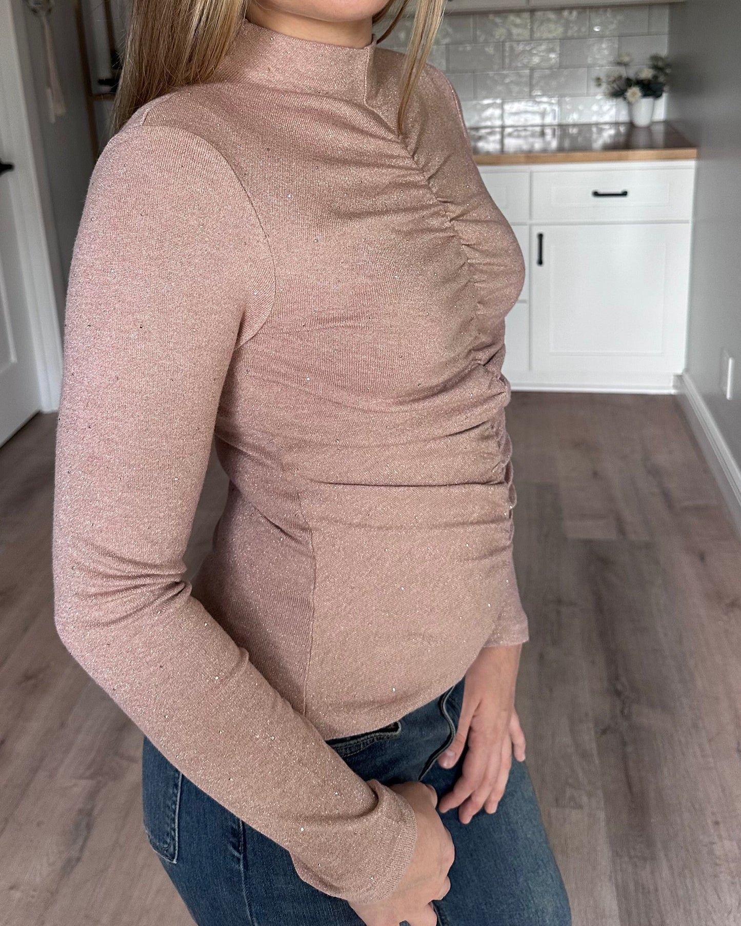 Side view of the Elena mock neck top showing allover ruching and flattering fitted shape