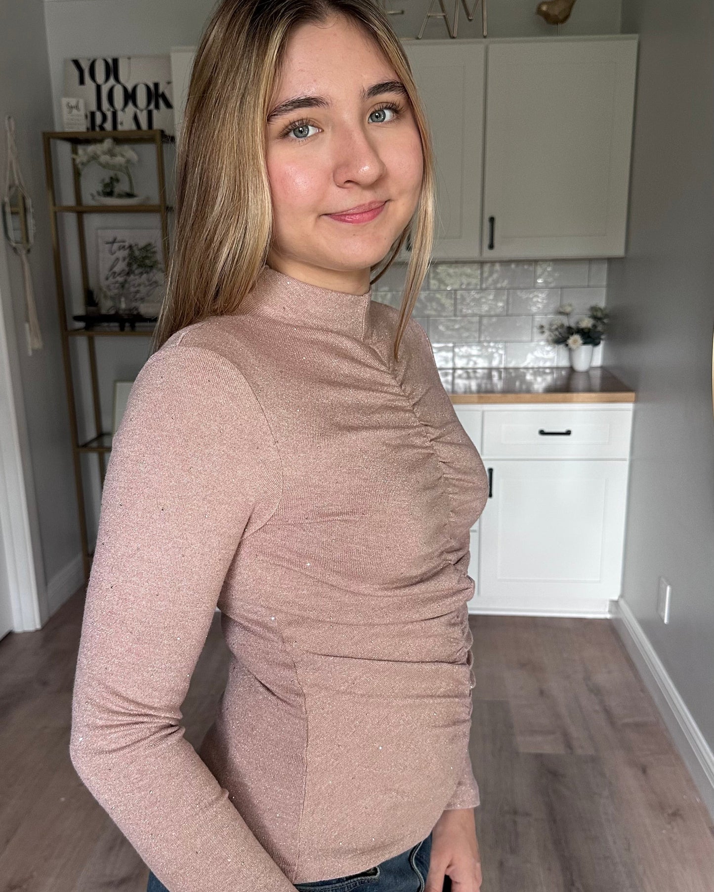 Side view of the Elena mock neck top showing allover ruching and flattering fitted shape