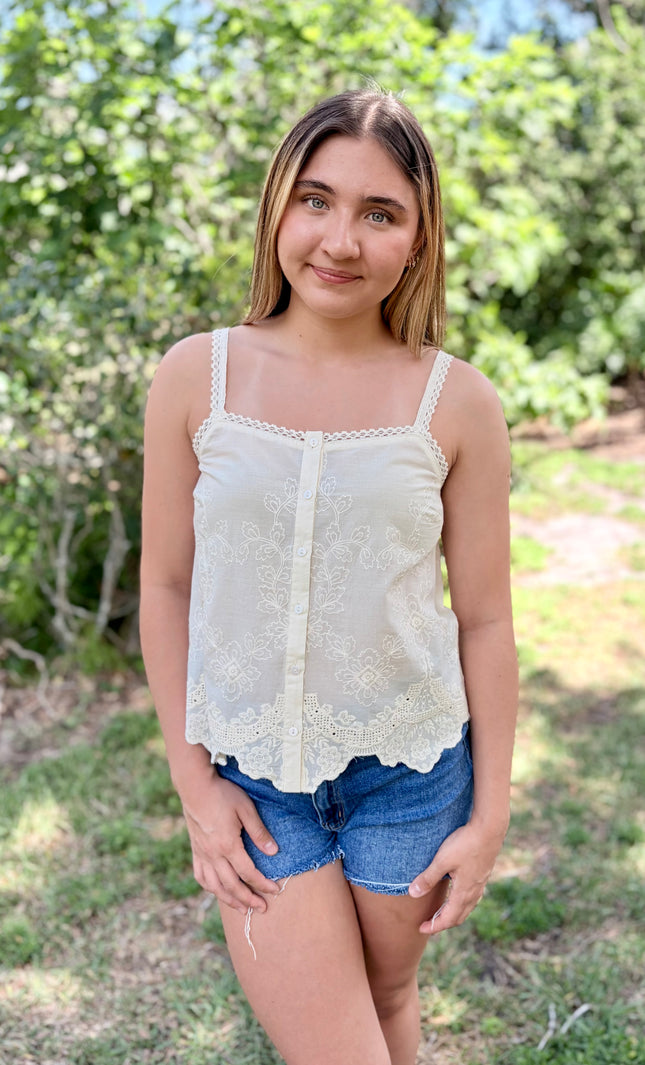 Front view of a white 100% cotton eyelet tank top with a square neckline and delicate button-front detail.