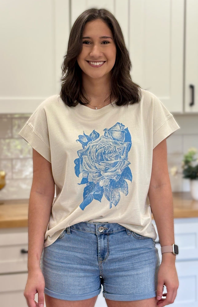 Cream graphic tee with blue faith-inspired design, ethically made and styled for a relaxed fit.