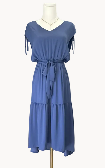 Blue dress on a mannequin against a light pink background