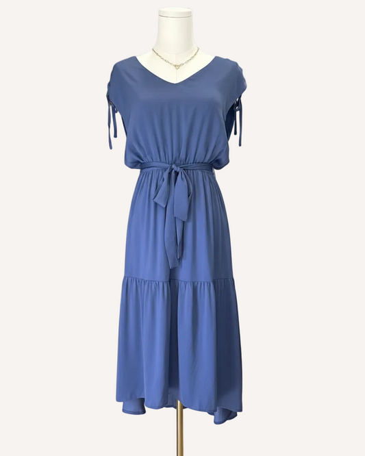 Blue dress on a mannequin against a light pink background