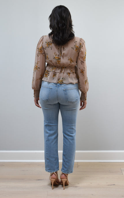 Floral Drift Blouse on soft linen background, featuring a delicate floral print and lightweight chiffon fabric.