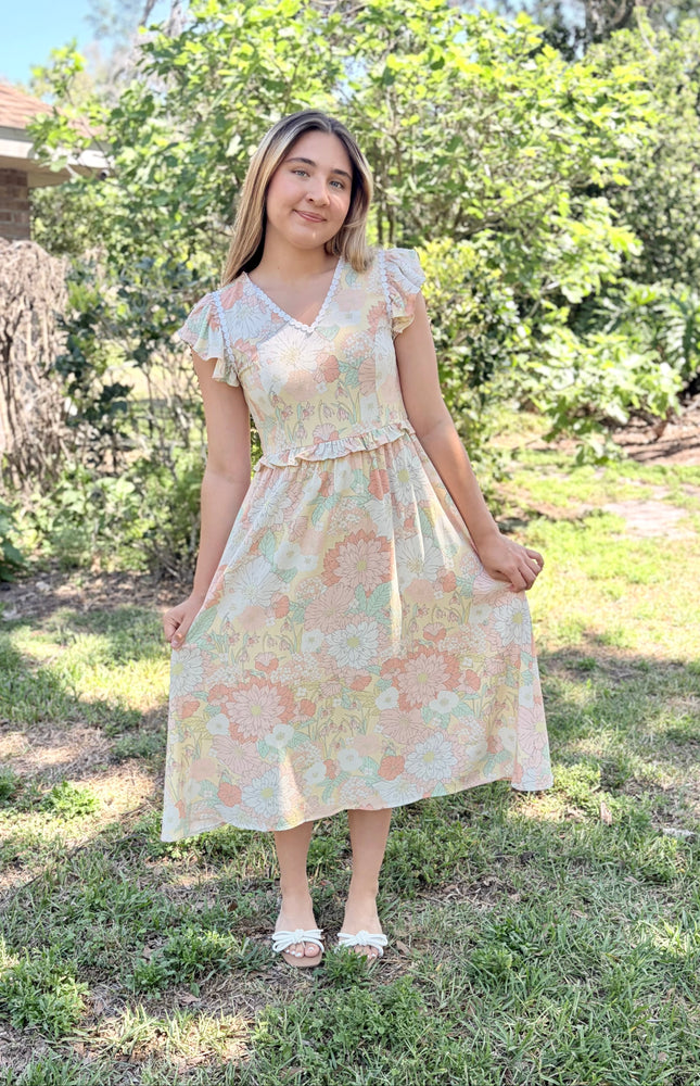 Floral print detail and scalloped neckline shown on woman wearing romantic midi dress
