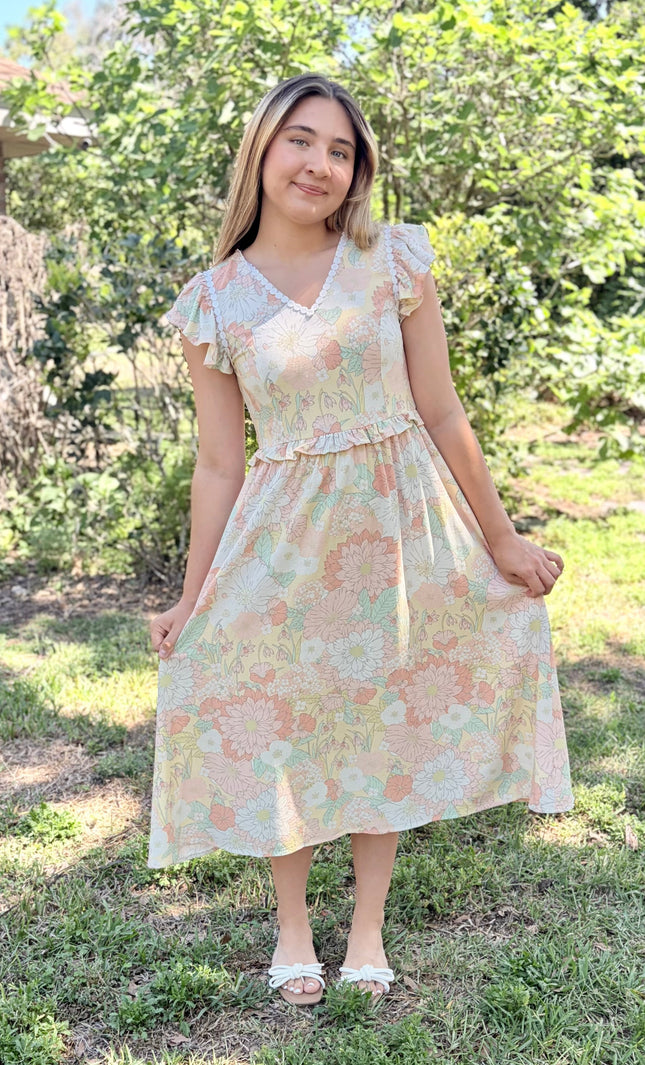 Floral print detail and scalloped neckline shown on woman wearing romantic midi dress