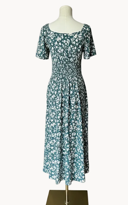 Floral dress on a mannequin against a light pink background