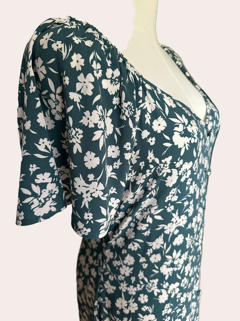 Teal green midi dress with delicate white floral print and v-neckline — soft feminine flow from Justyna Grace Boutique.