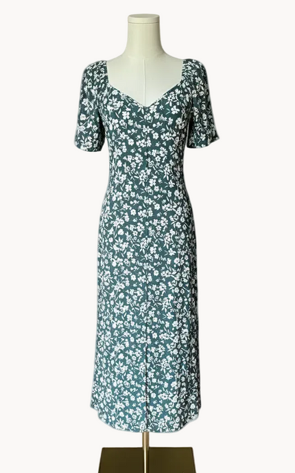 Floral dress on a mannequin against a light pink background