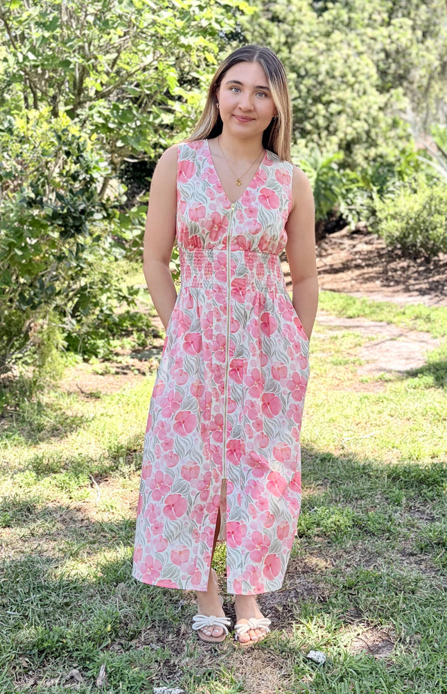 Woman wearing Garden Floral Cotton Midi Dress in watercolor floral print, size Small, front view showing V-neckline, smocked waist, center-front zipper, and modest midi length