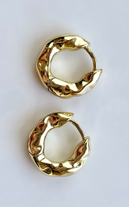 Pair of gold hoop earrings on a light gray background