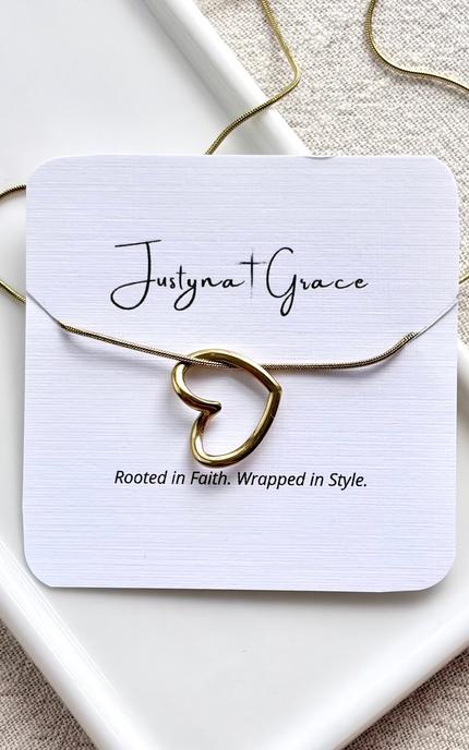 gold heart necklace on soft linen background with natural light, delicate everyday jewelry