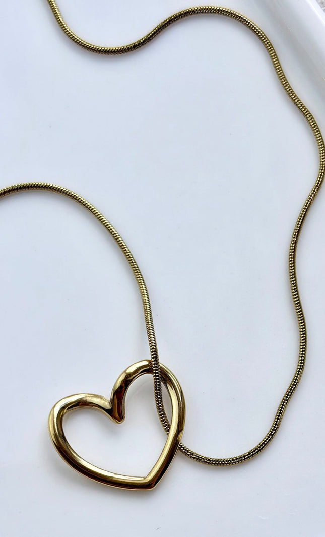 gold heart necklace on soft linen background with natural light, delicate everyday jewelry