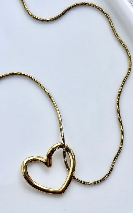 gold heart necklace on soft linen background with natural light, delicate everyday jewelry