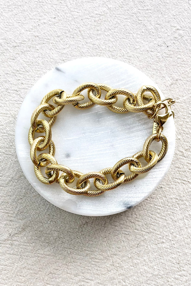 gold cable link bracelet on soft linen background in natural light, chunky everyday jewelry
