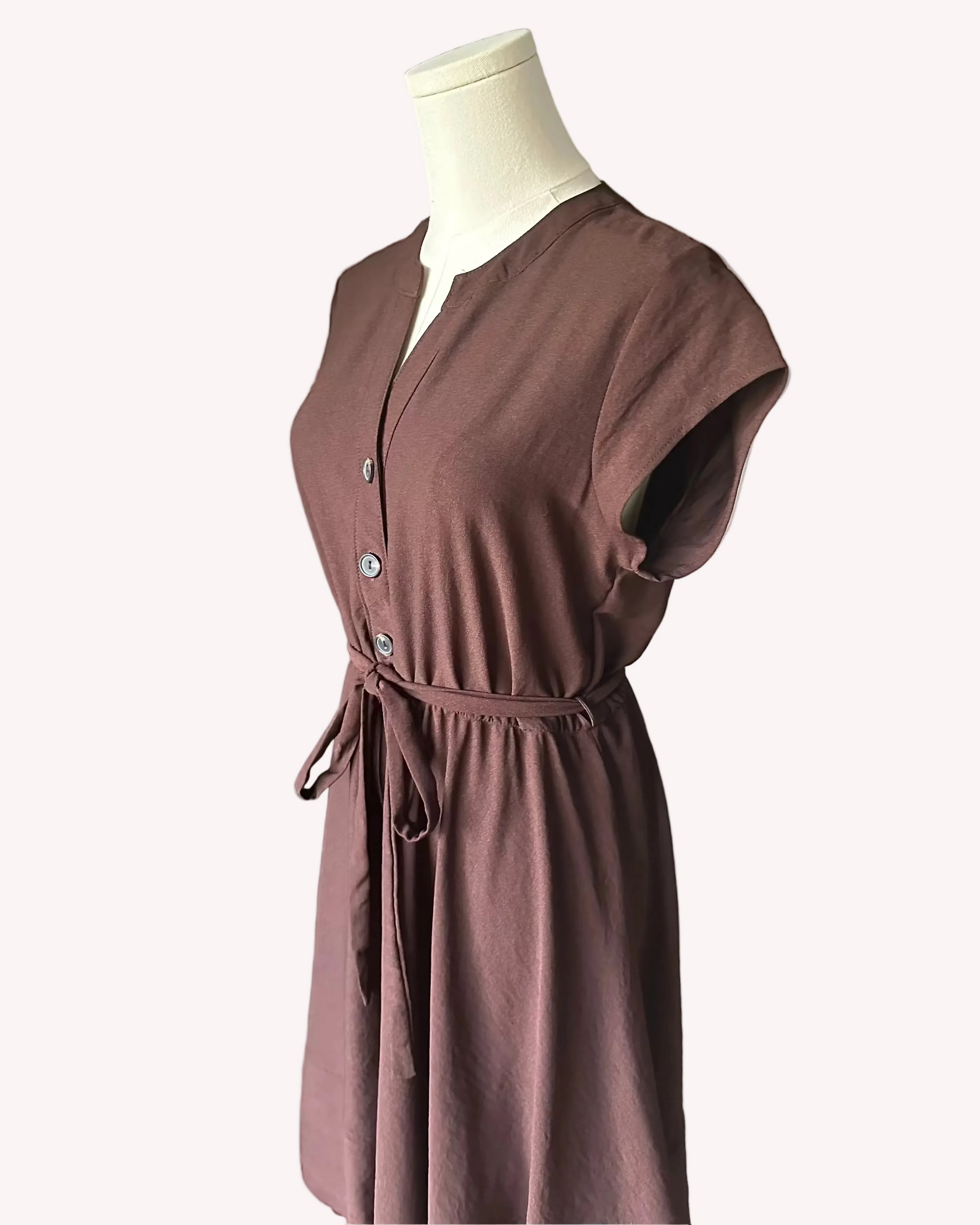 Brown dress on a mannequin against a white background