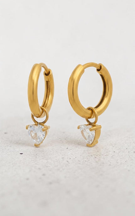 Close-up of heart-shaped cubic zirconia crystal drop on gold hoop earring showing sparkle and 18k gold PVD finish