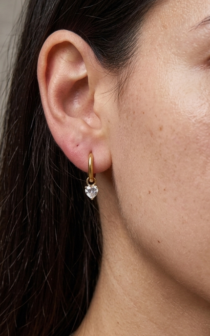 Heart crystal drop hoop earrings worn on ear showing feminine silhouette and delicate sparkle detail