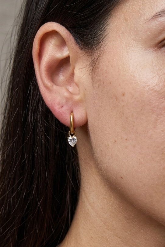 Heart crystal drop hoop earrings worn on ear showing feminine silhouette and delicate sparkle detail