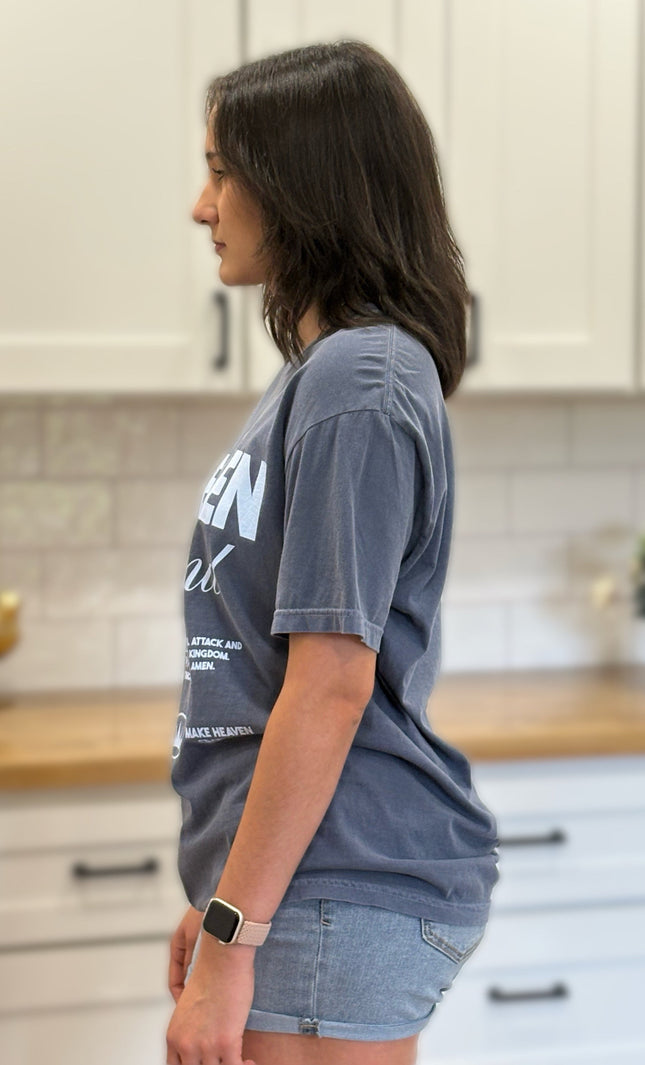 Woman wearing a blue t-shirt with text on a plain background
