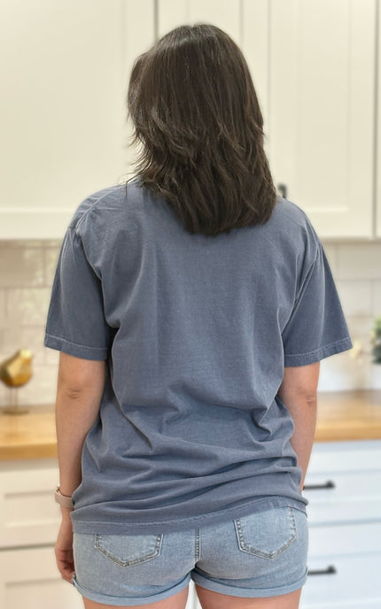 Person wearing a blue t-shirt and denim shorts on a white background
