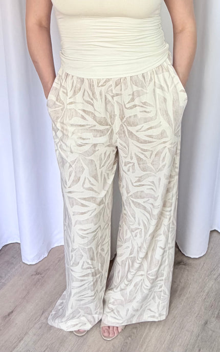 Close-up front view of island leaf print pants with hands in pockets, highlighting the lightweight rayon linen fabric and tropical print detail.