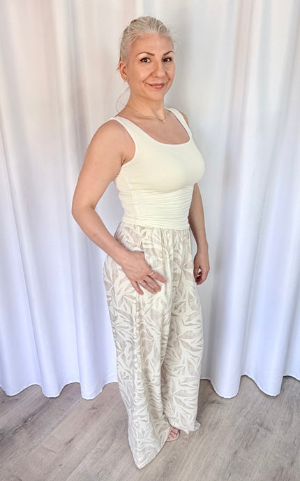 Side view of women's island leaf print straight leg pants with hand in pocket, showcasing the relaxed fit and lightweight rayon linen fabric.
