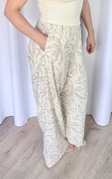 Close-up side view of island leaf print pants with hand in pocket, highlighting the lightweight rayon linen fabric and relaxed drape.