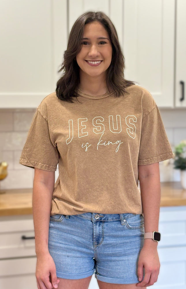 Gold mineral-wash “Jesus Is King” graphic tee with relaxed unisex fit and vintage garment-dyed finish.