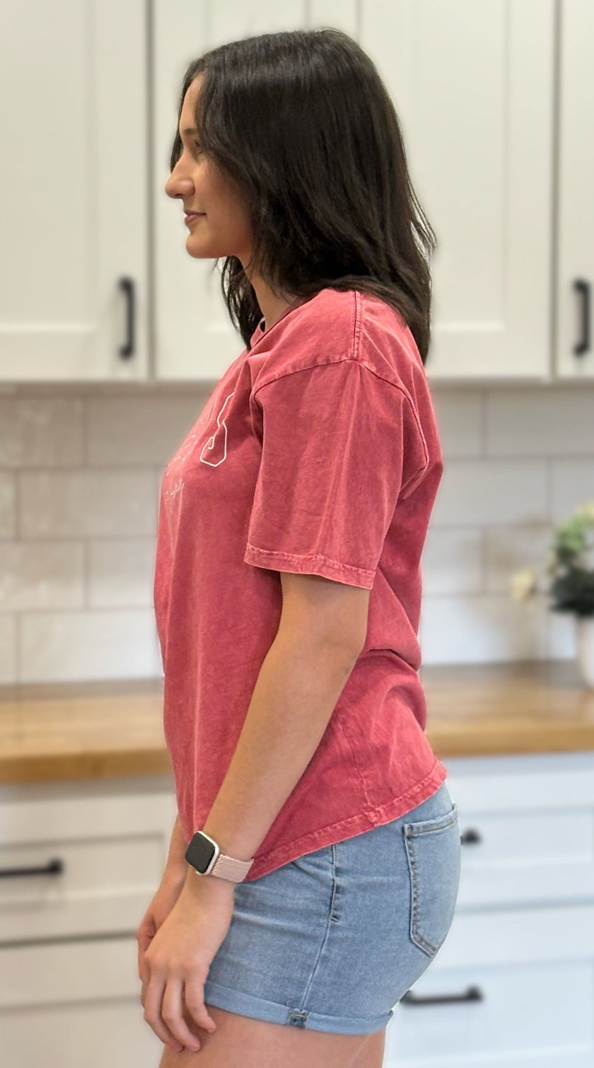 Red mineral-wash “Jesus Is King” graphic tee with relaxed unisex fit and vintage garment-dyed finish.