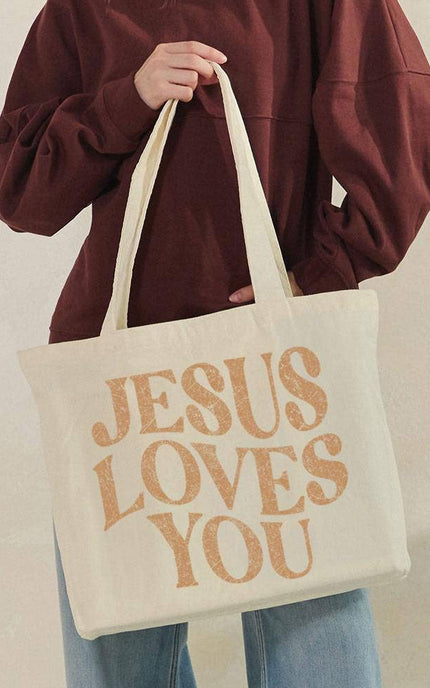 Jesus Loves You canvas tote bag front view with bold faith graphic