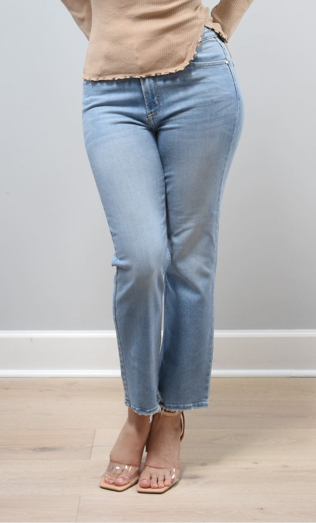 Light-wash straight-leg jeans with mid-high rise shown from the front on model, styled with neutral top.